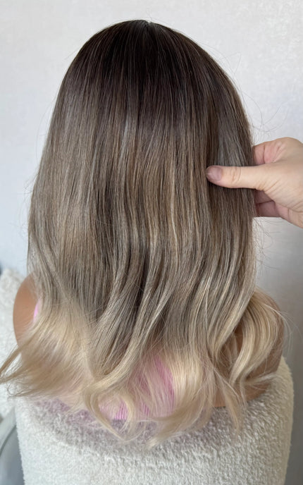 back view holding hair dark root to platinum blonde ends, glueless fringe synthetic wig.