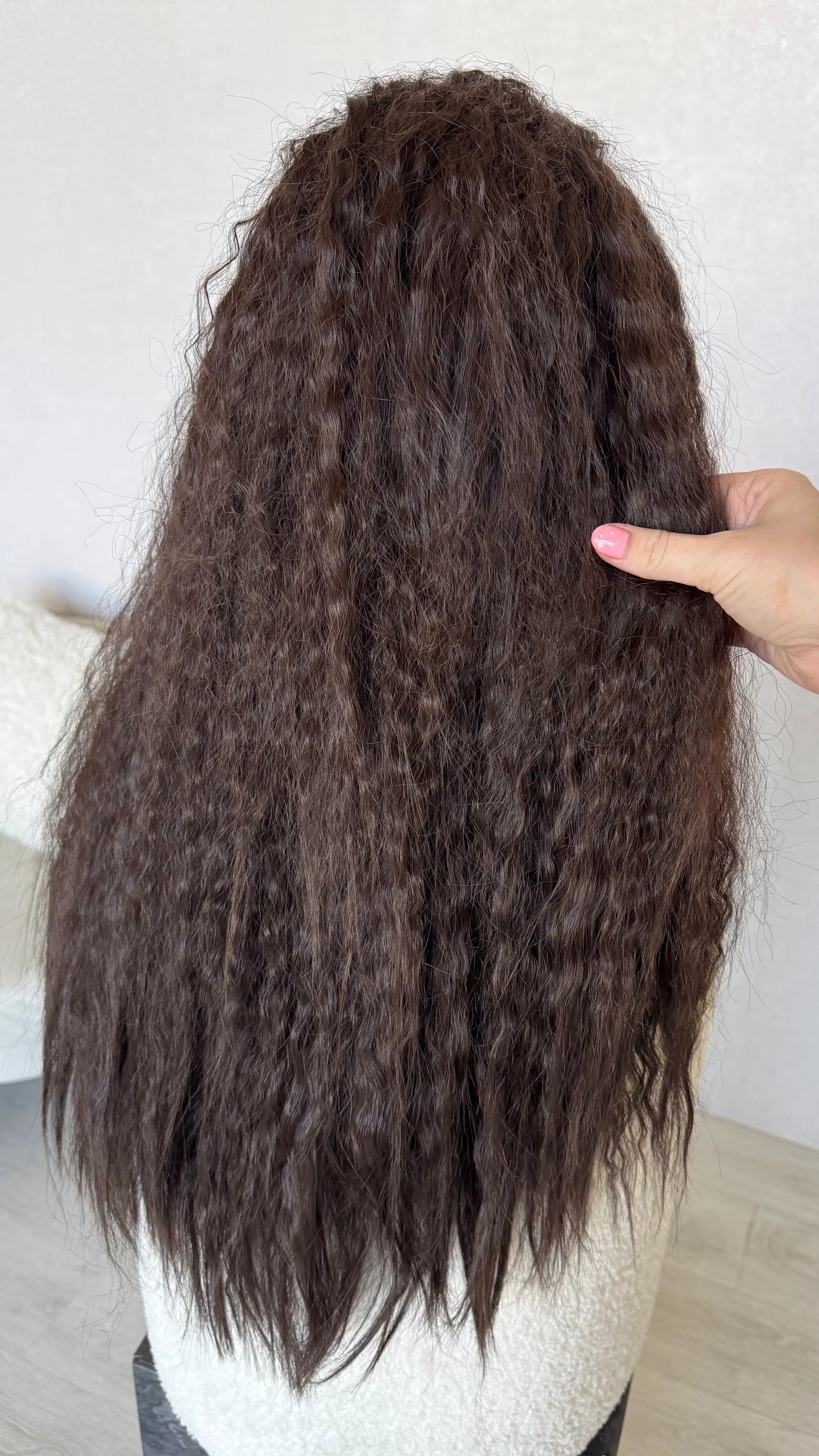 back view holding long dark brown hair curly waves.