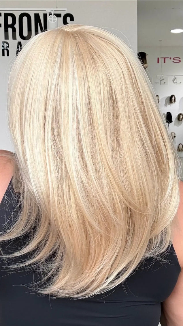 up close back shot showing light blonde hair colour with middle part and soft layers.