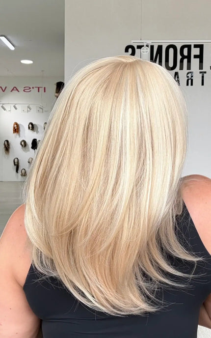back view of light blonde hair with soft layers, middle part and soft wispy ends.