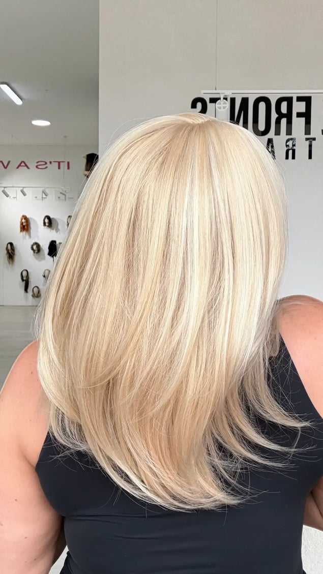 back view of light blonde hair with soft layers, middle part and soft wispy ends.