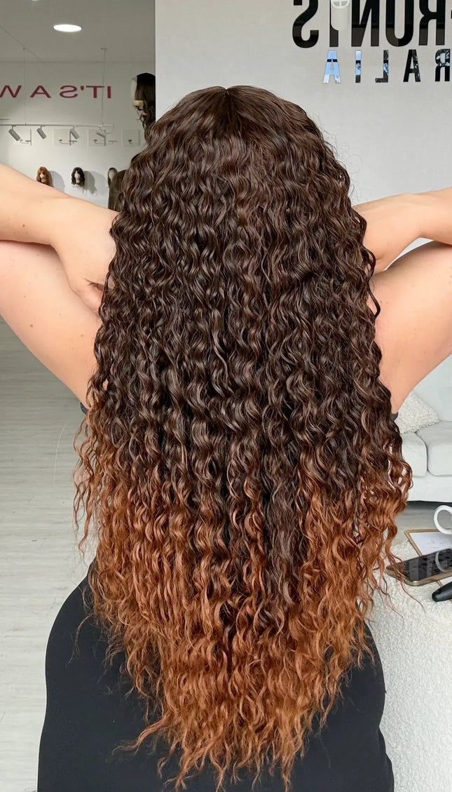 back view showing long length curly brunette hair, with lighter chesnut brunette ends, heat safe synthetic wig for hairloss, glueless wig cap for easy everyday wear.