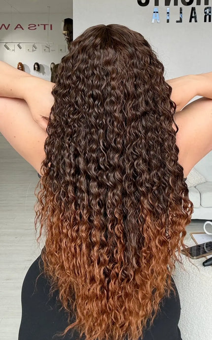 back view showing long length curly brunette hair, with lighter chesnut brunette ends, heat safe synthetic wig for hairloss, glueless wig cap for easy everyday wear.