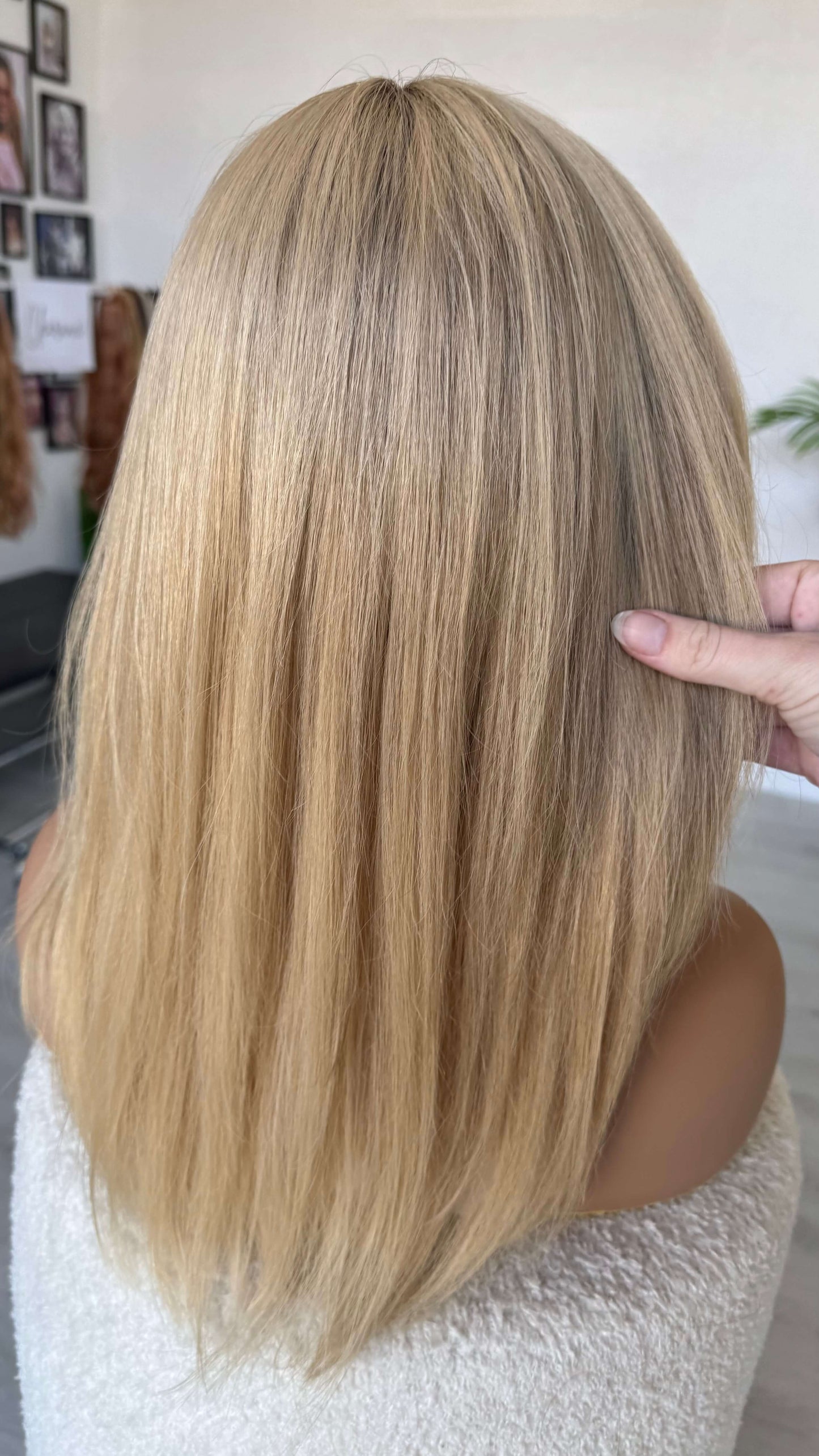 human hair lacefront wig from behind holding the hair, light blonde wig.