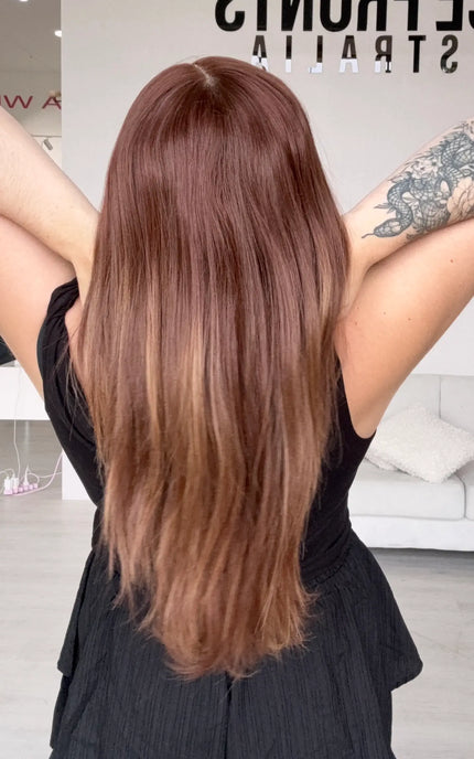 a back view showing long length straight hair with a middle part. soft fade of colour to ends.