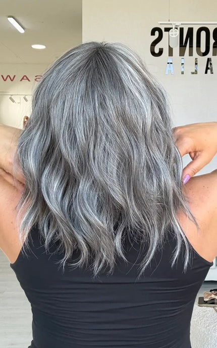back view of wavy ash grey hair with soft platinum highlights, middle part with fringe.