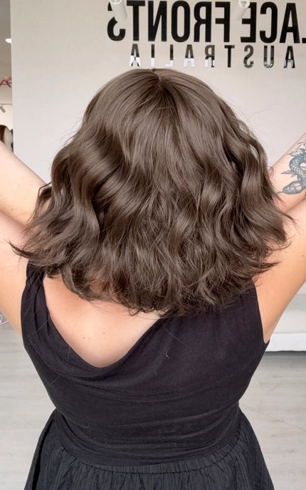 a back view showing wavy brunette hair colour and texture, full body of hair, middle part, 10-11 inch length.