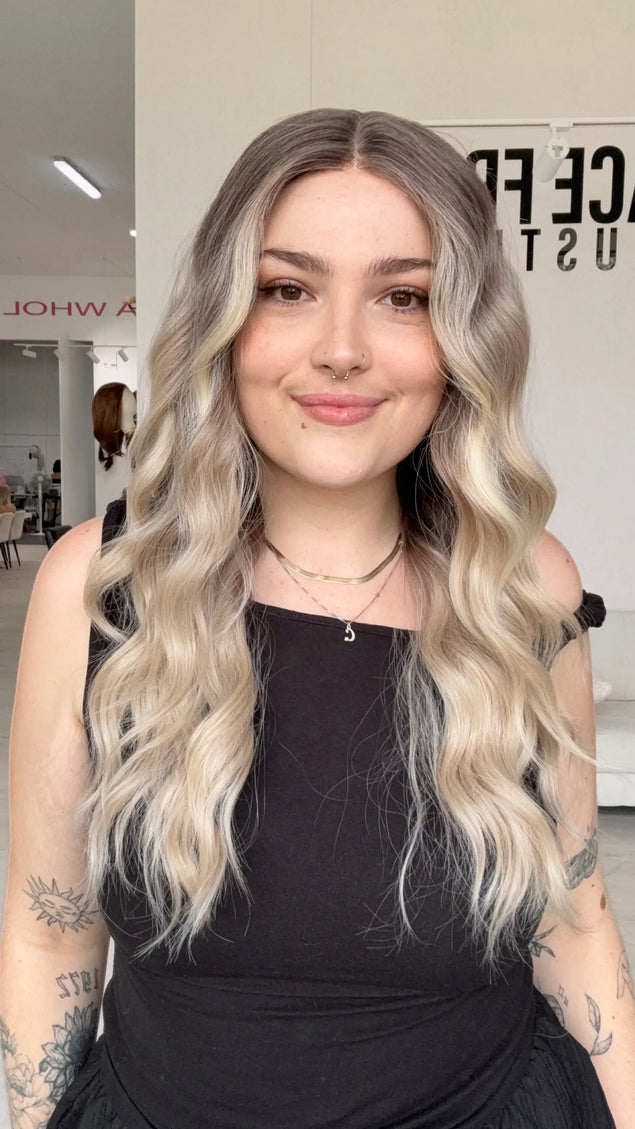 beachy wave long length blonde hair with cool dark blonde root, realistic hairline with a glueless cap and adjsutable straps. heat safe blonde hair for easy styling and a colour that doesnt fade!