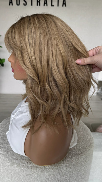 blonde wig side on, holding hair to show colour. fringe wig. brazilian hair.