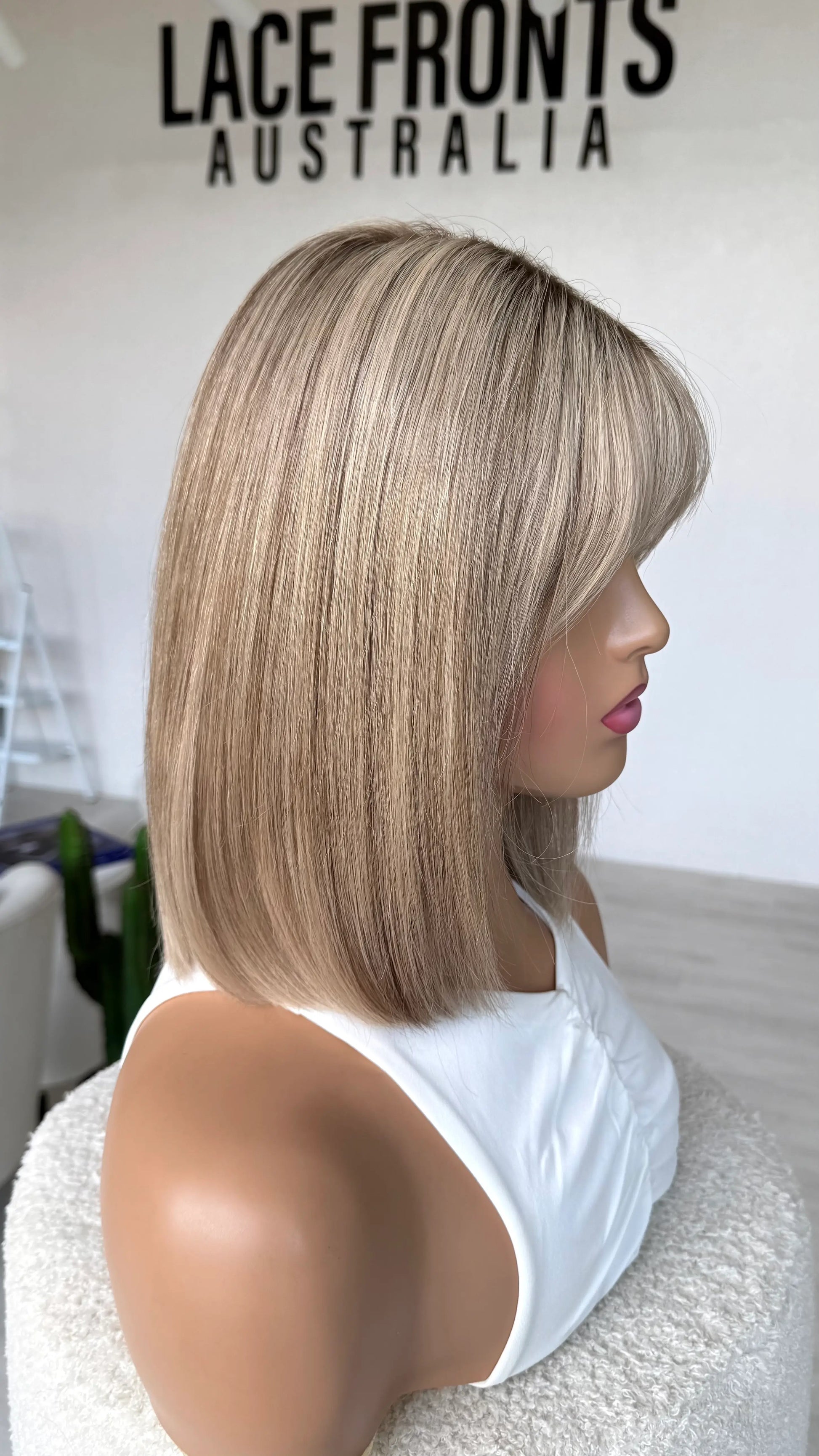 side on view showing blonde colour hair, darker root, straight hair bob length 12 inch. human hair.