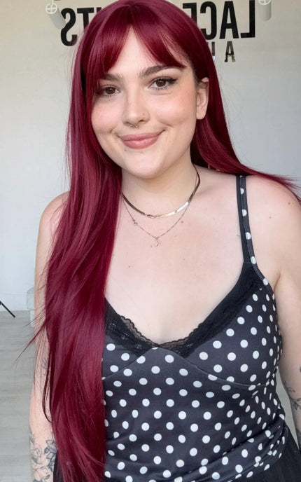 long length burgundy synthetic wig with a long fringe and face framing layers, middle part.