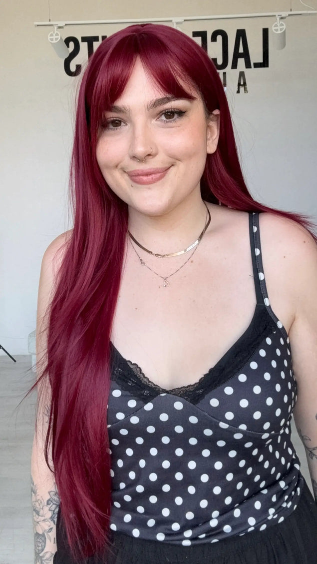 long length burgundy synthetic wig with a long fringe and face framing layers, middle part.