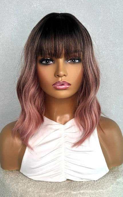pink synthetic bob from the front on. dark root with bright pink wavy hair.