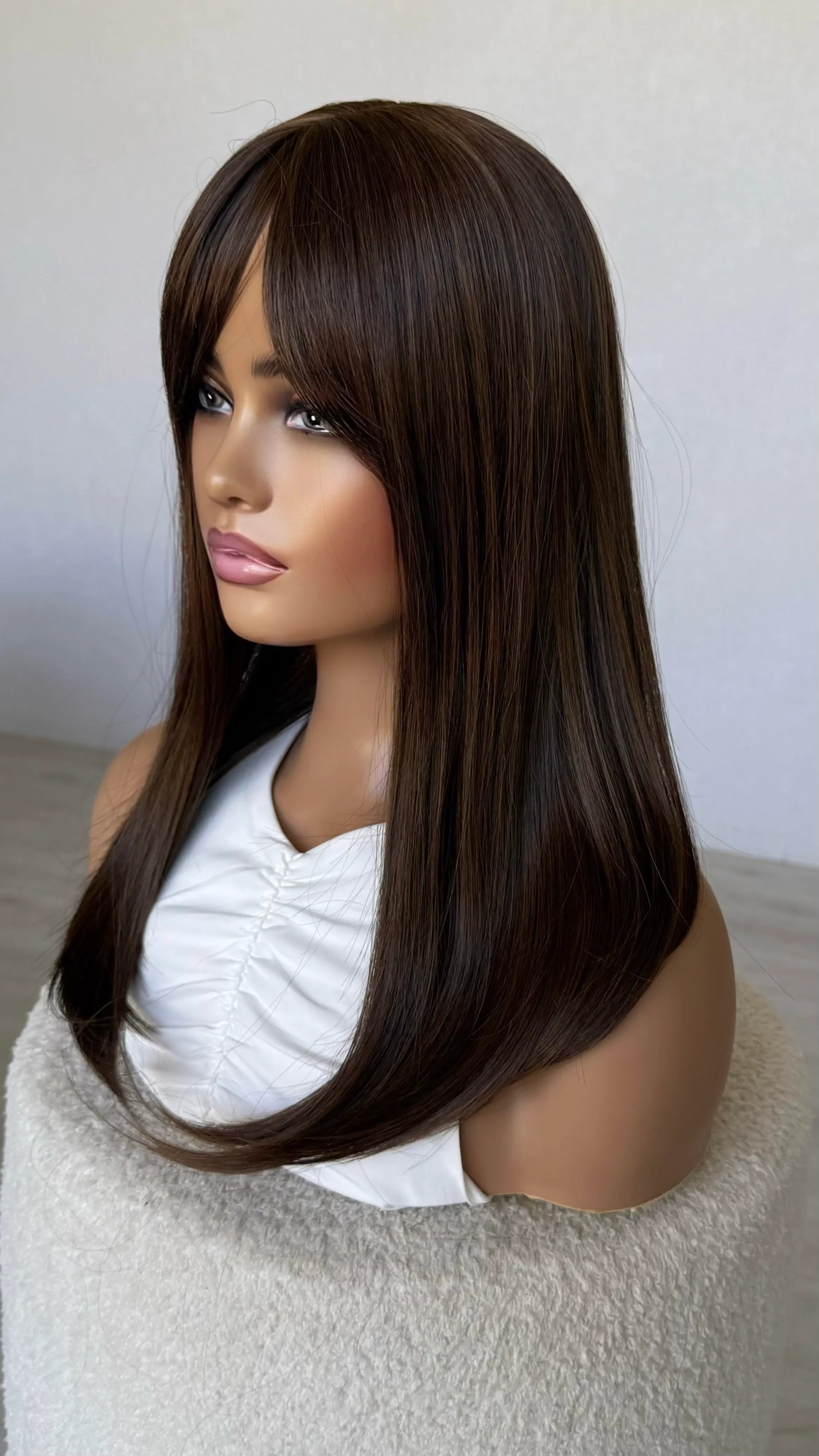 synthetic brunette topper, long fringe parted to the side.