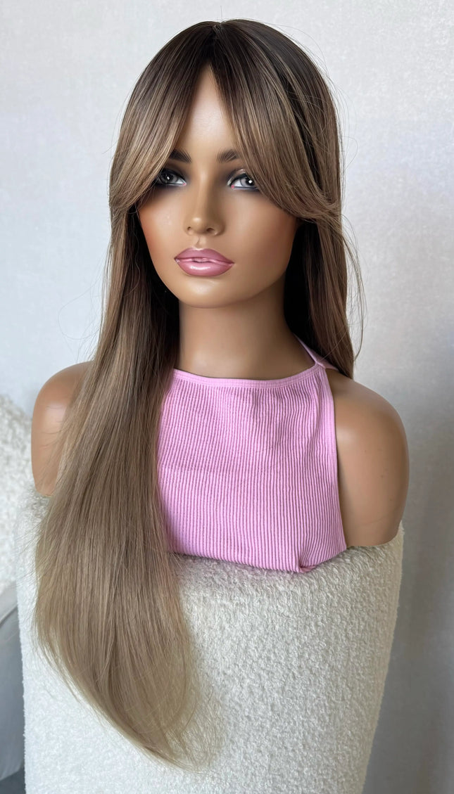 long hair champagne toned hair with dark root, middle part with curtain bangs.