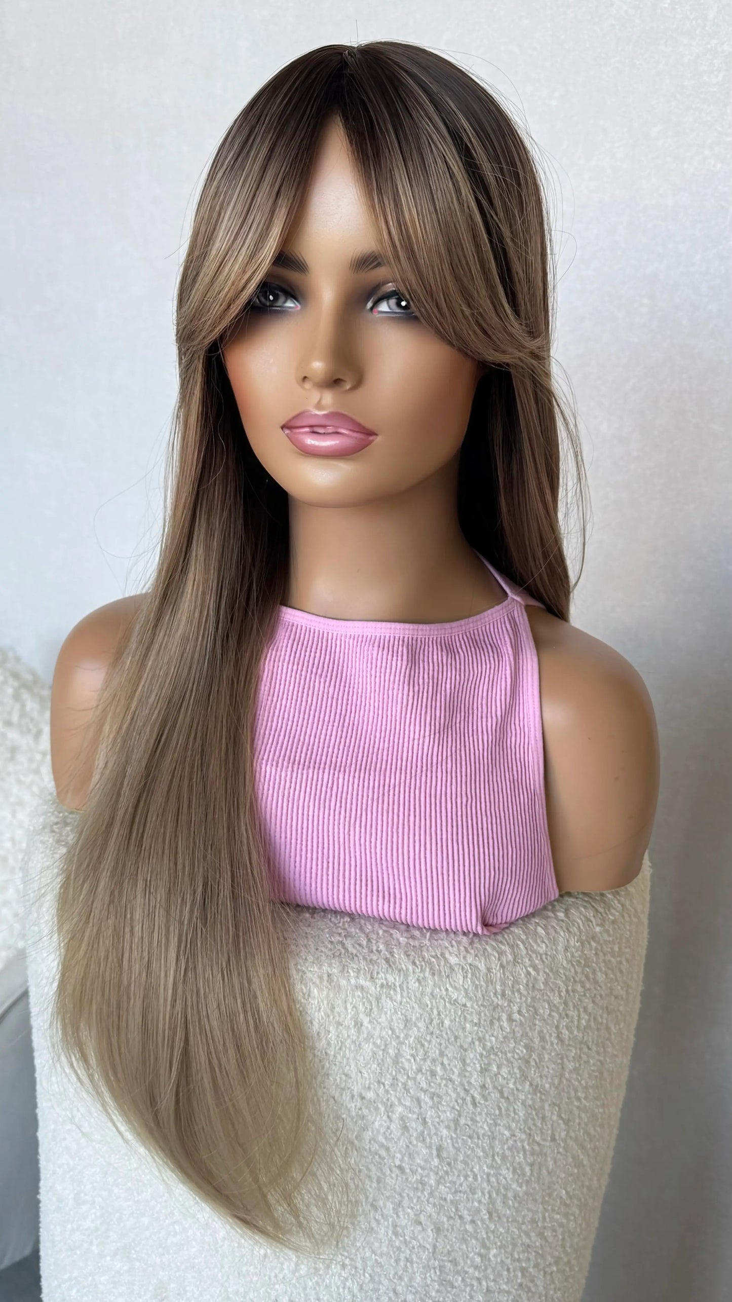 long hair champagne toned hair with dark root, middle part with curtain bangs.
