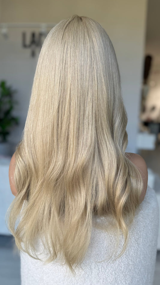 back view of hair colour. bright sandy blonde hair, slight wave, no root. natural hair wig made in australia.