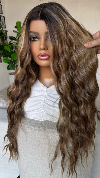 holding brunette hair with caramel light highlights, multi toned brunette synthetic. lacefront, natural wig.