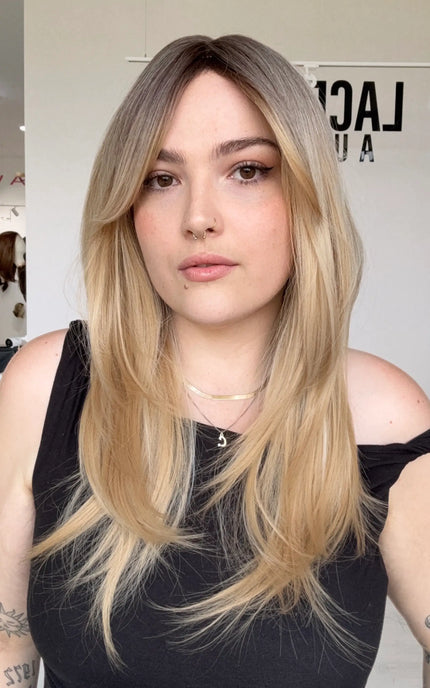 a vanilla blonde synthetic wig with a glueless cap and curtain bangs, middle part with long curtain bangs parted to the side. 