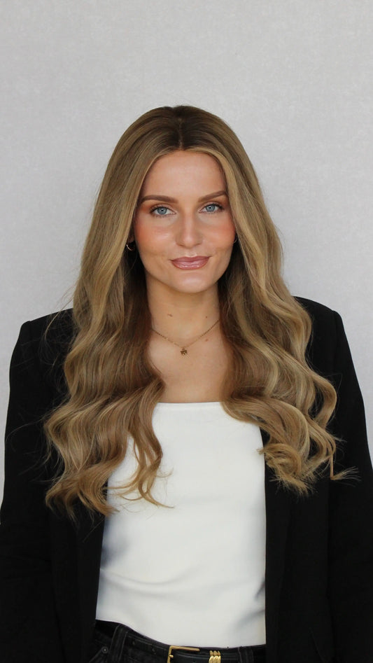 lacefront brazilian remy human hair wig, with face framing highlights and a darker root. styled with a wave.