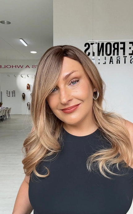 a soft golden brunette with light warm blonde ends, slight side part with long face framing layers. an elegant classy look.