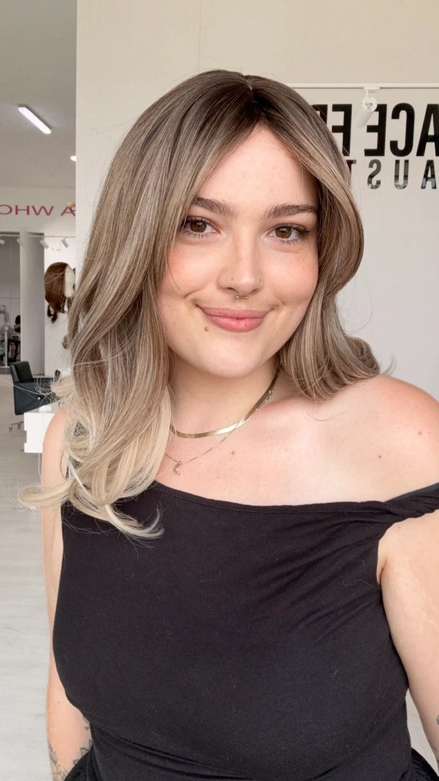 half hair forward half back, ash ombre hair colour, mid length hair with slight curled end, middle part, dark root to platinum ash ends.