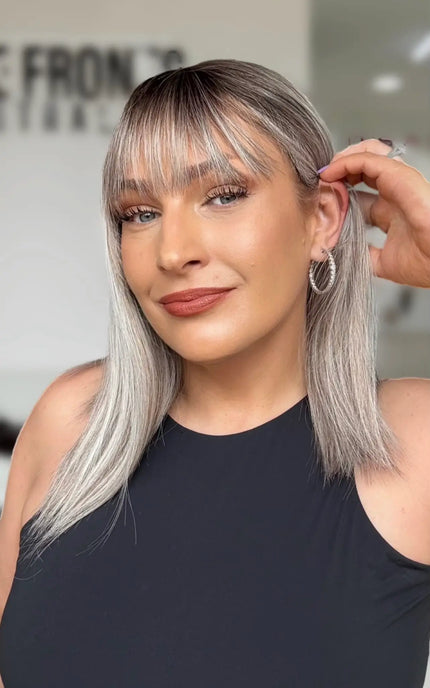 right side ear tucking on light grey hair with darker root and soft fringe.