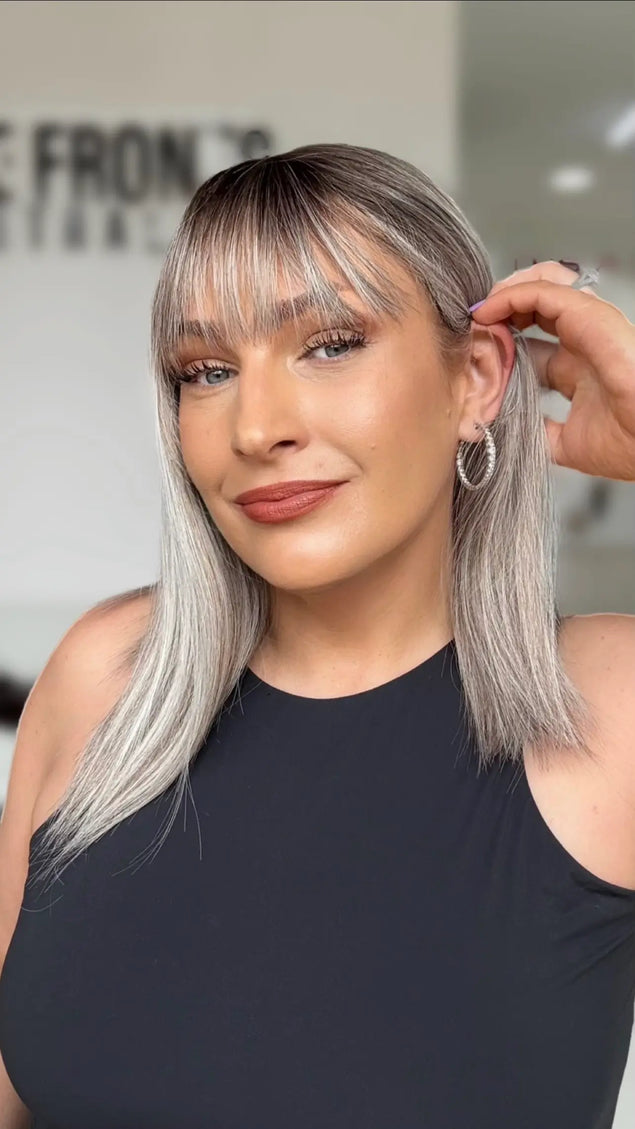 right side ear tucking on light grey hair with darker root and soft fringe.