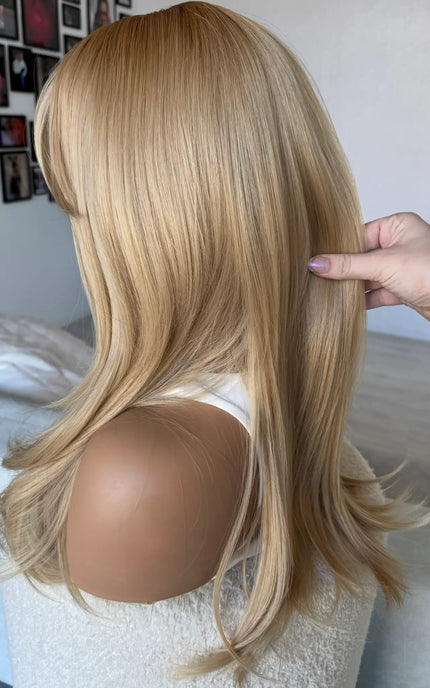 golden hair from the back view, holding to show colour and length 