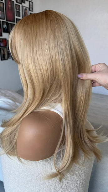 golden hair from the back view, holding to show colour and length 