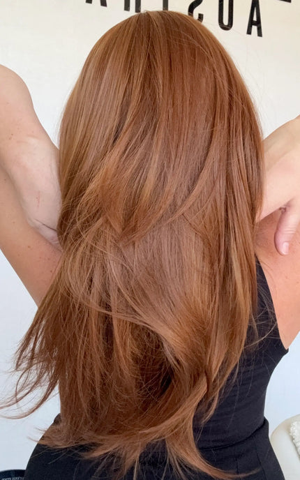 layered copper hair synthetic topper, middle part with curtain bangs.