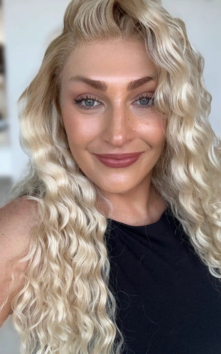 a realistic looking lace front wig with dakrer blonde root to lighter creamy blonde ends, curly long hair.