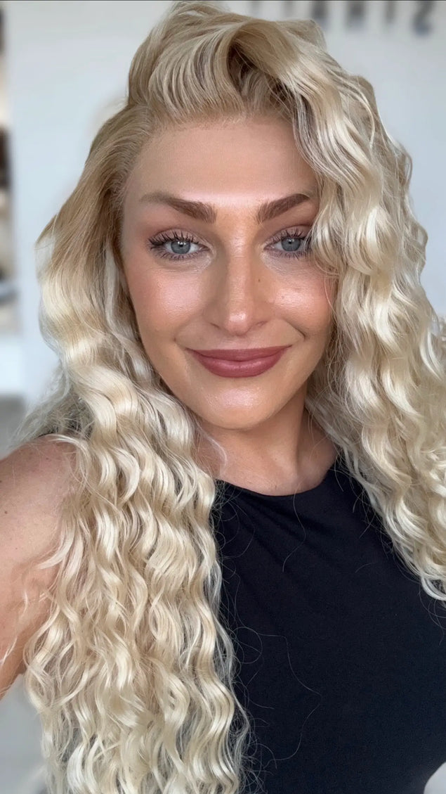 a realistic looking lace front wig with dakrer blonde root to lighter creamy blonde ends, curly long hair.