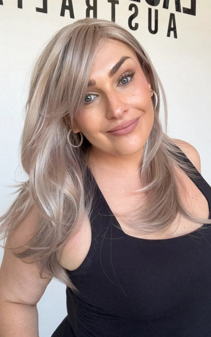 lilac toned layered synthetic wig, heat safe and glueless with curtain bangs.