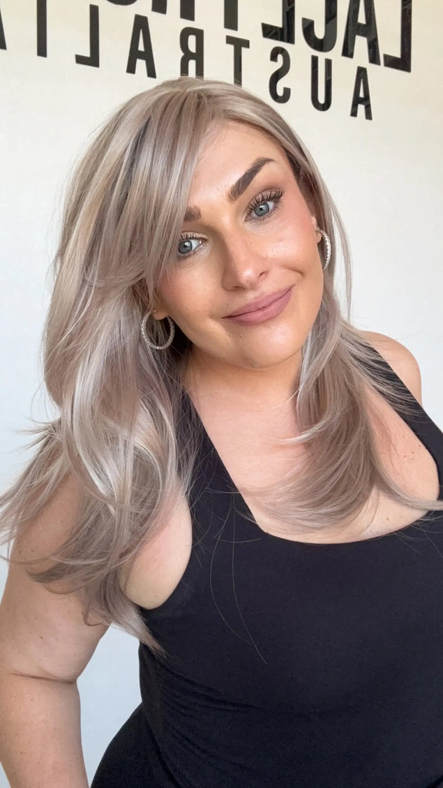 lilac toned layered synthetic wig, heat safe and glueless with curtain bangs.
