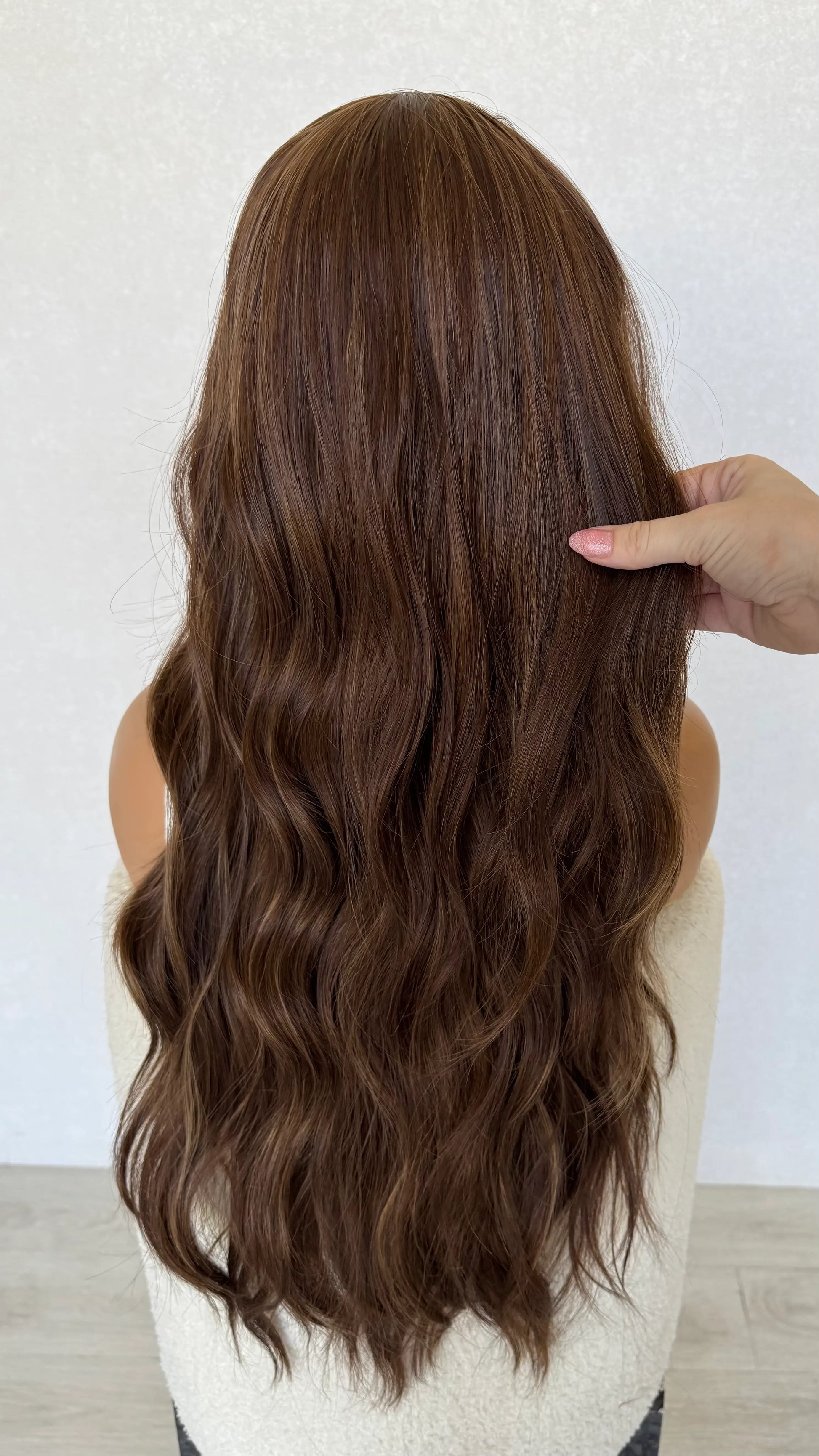holding long copper synthetic hair, wavy hair, heat safe, middle part, glueless.