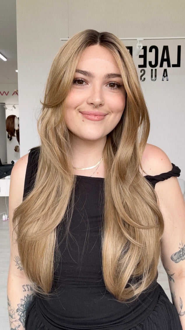long length hair with middle part and long curtain bangs parted to the side, dark honey blonde hair with a shadow root for dimension, natural looking hairline.