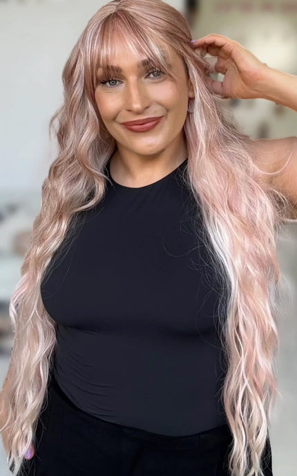 long length wavy pink hair wig with middle part and long wispy fringe, light layers around face and fringe. light pink pearly hair.