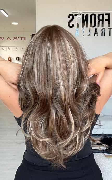 Medium length 20–22 inch warm brunette hair with ash and honey blonde highlights and light layers throughout.