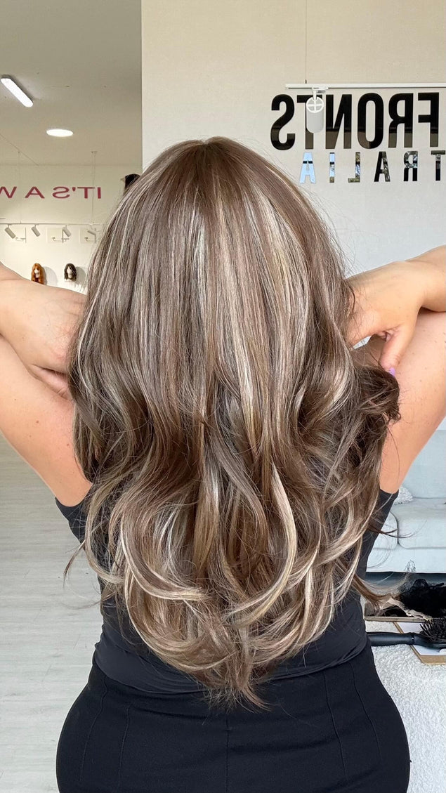 Medium length 20–22 inch warm brunette hair with ash and honey blonde highlights and light layers throughout.