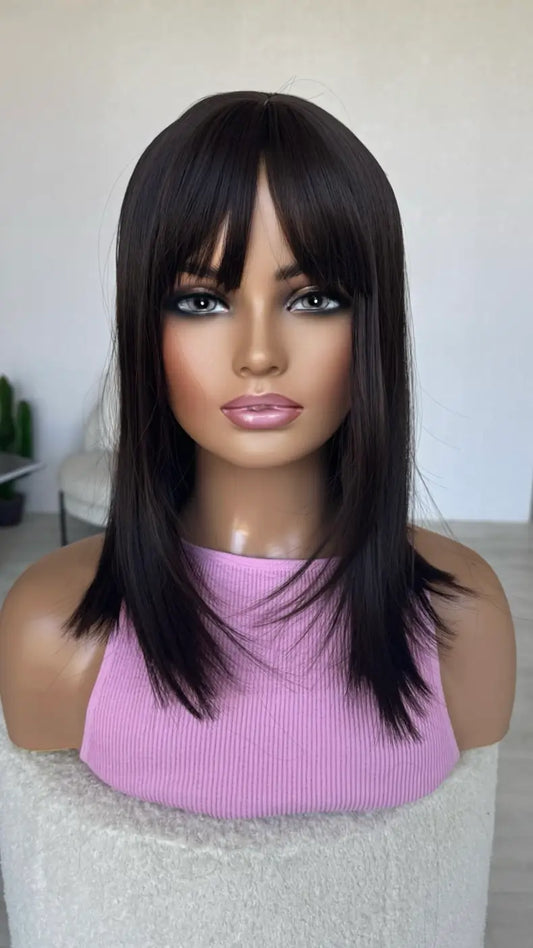 Mannequin head with a black wig and pink top on a white background