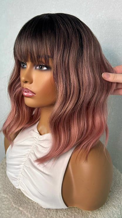side on, holding the pink hair. synthetic hair heat-friendly. dark root to pink hair.