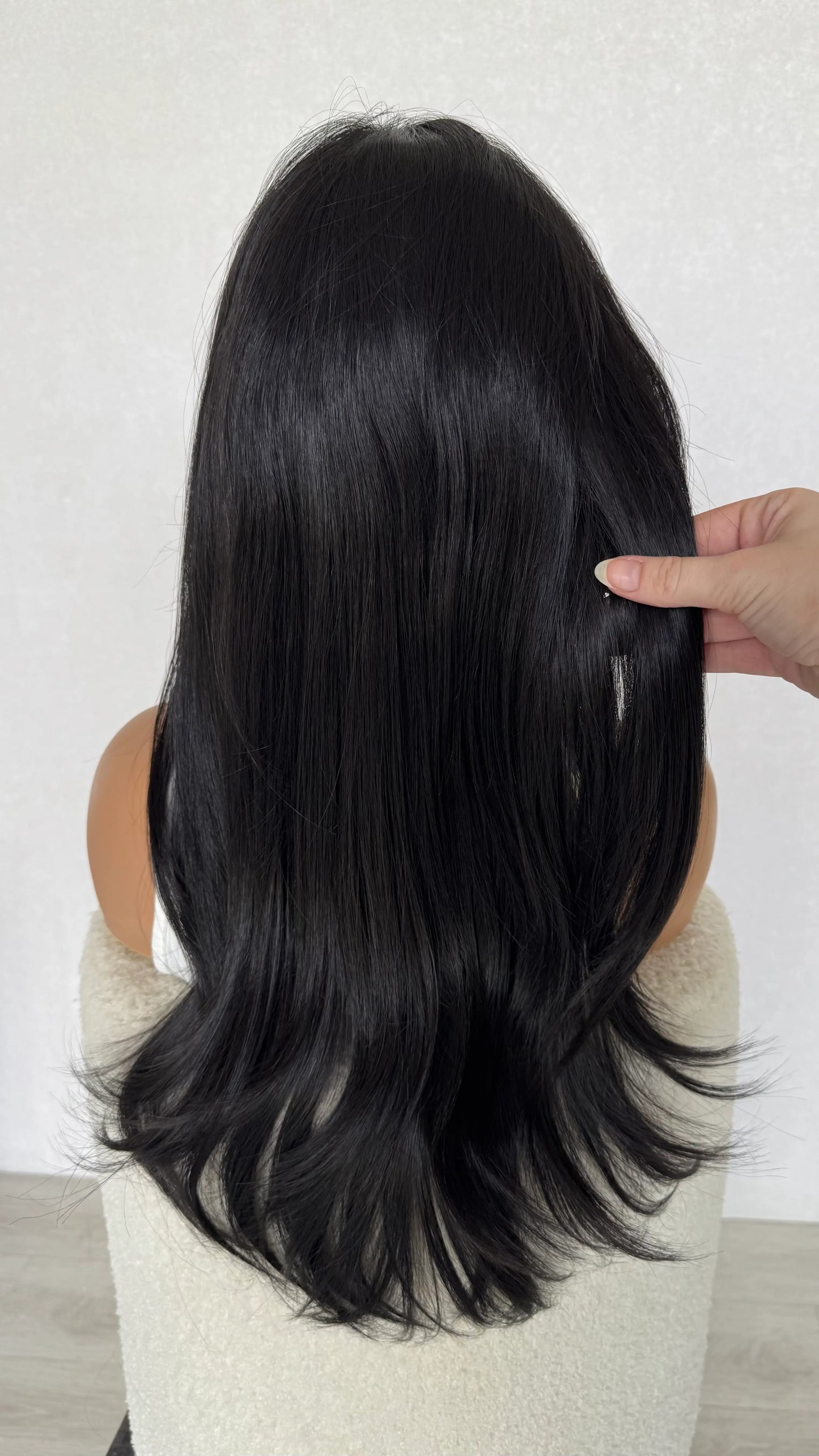 Long layered black hair wig from behind, holding long layered hair. glueless wig australia, synthetics.
