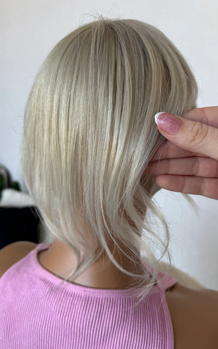 blonde topper from behind 12 inch length holding the hair.
