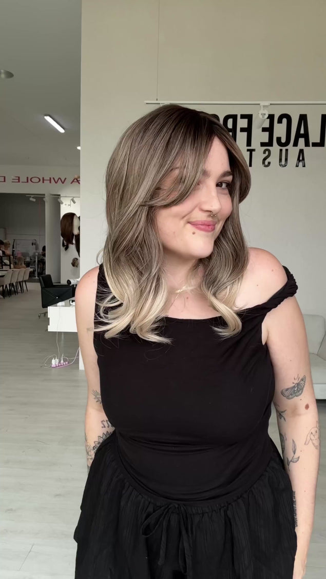 ash blonde ombre, darker root to ash mids and platinum ends, slight curl, middle part and curtain bangs. heat safe synthetic hair for easy styling, a glueless cap with adjustable straps
