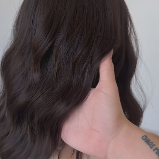 dark wavy brunette synthetic wig with heat safe hair and glueless cap.