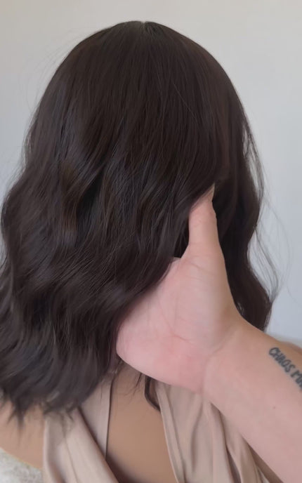 dark wavy brunette synthetic wig with heat safe hair and glueless cap.