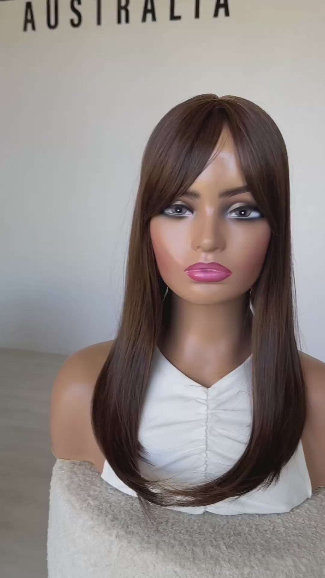 chestnut brunette middle part topper, fringe parted to the side.