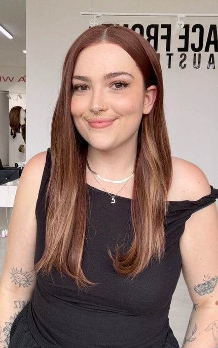 hair tucked behind ear with a middle part, long red copper synthetic hair that can be heat styled, middle part can be changed.