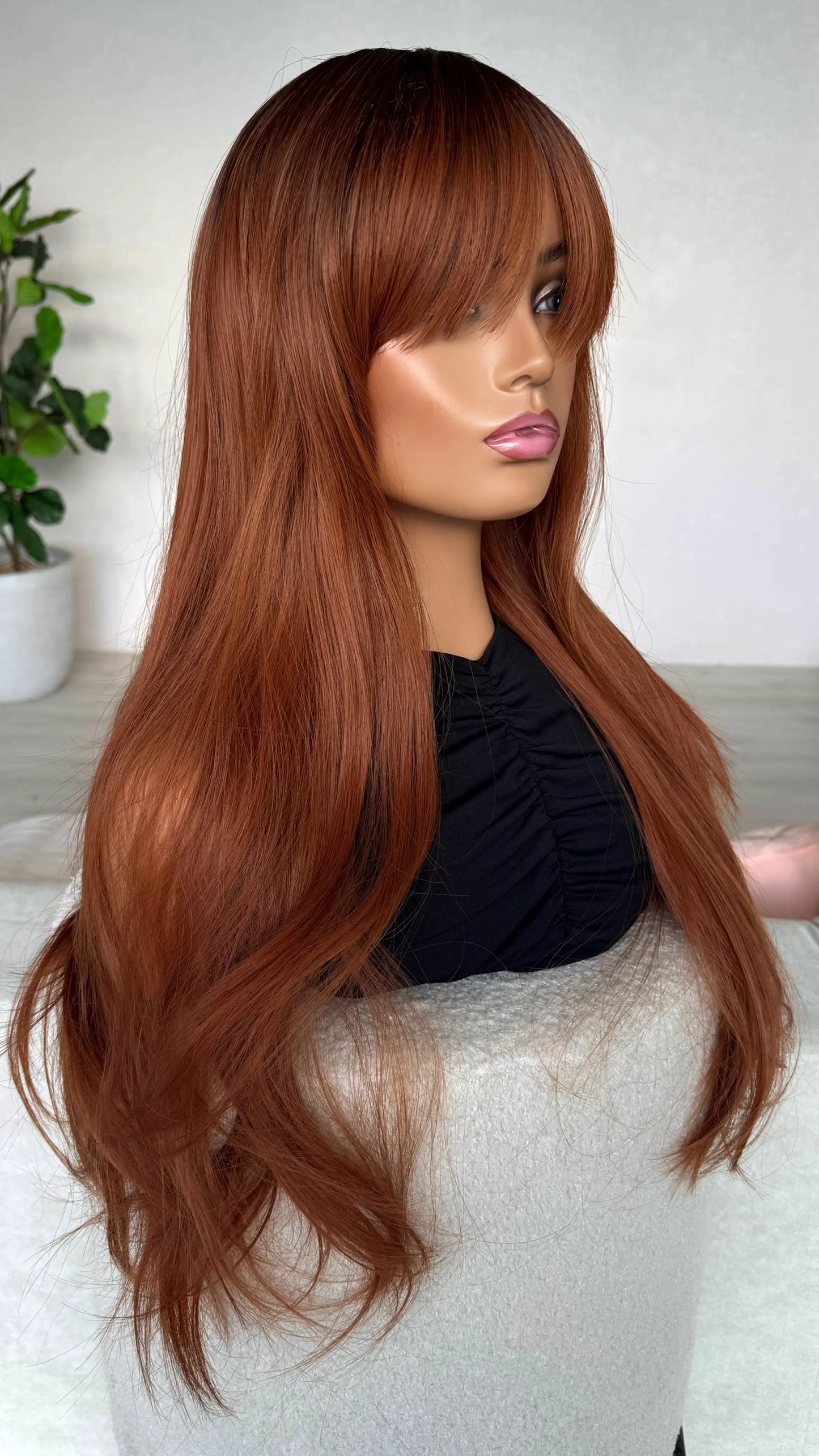 side on view, red copper wig, long straight hair with a fringe. heat safe.